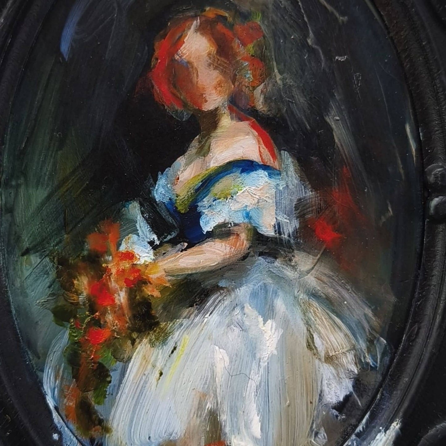 Close-up of a decorative oval frame with a painting by Anita DeSoto of a woman holding flowers on a dark background