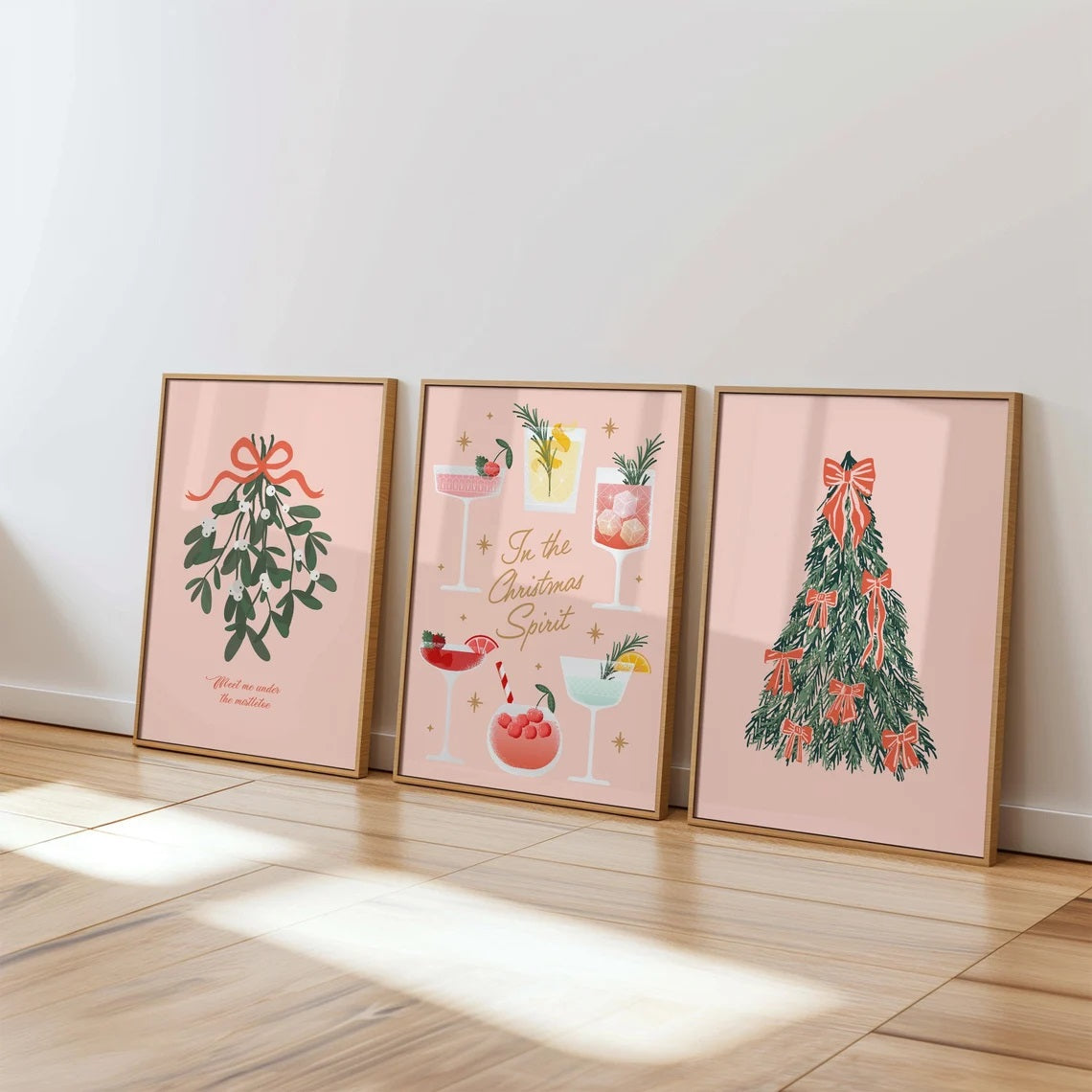 Three framed Christmas-themed prints on a wall.