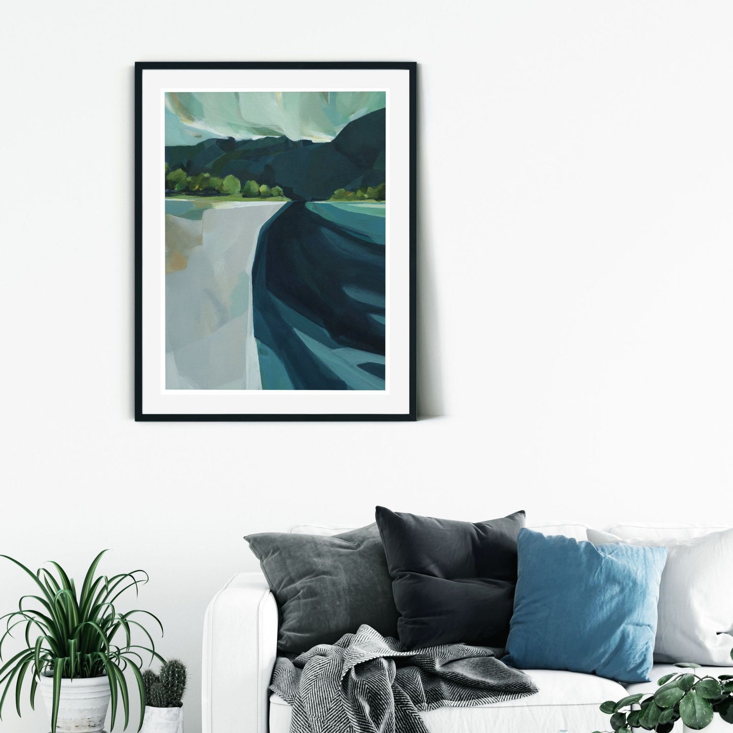 Limited edition art print titled "The Haast" by Holly Roach, depicting a stylized West Coast landscape displayed on a white wall above a couch..