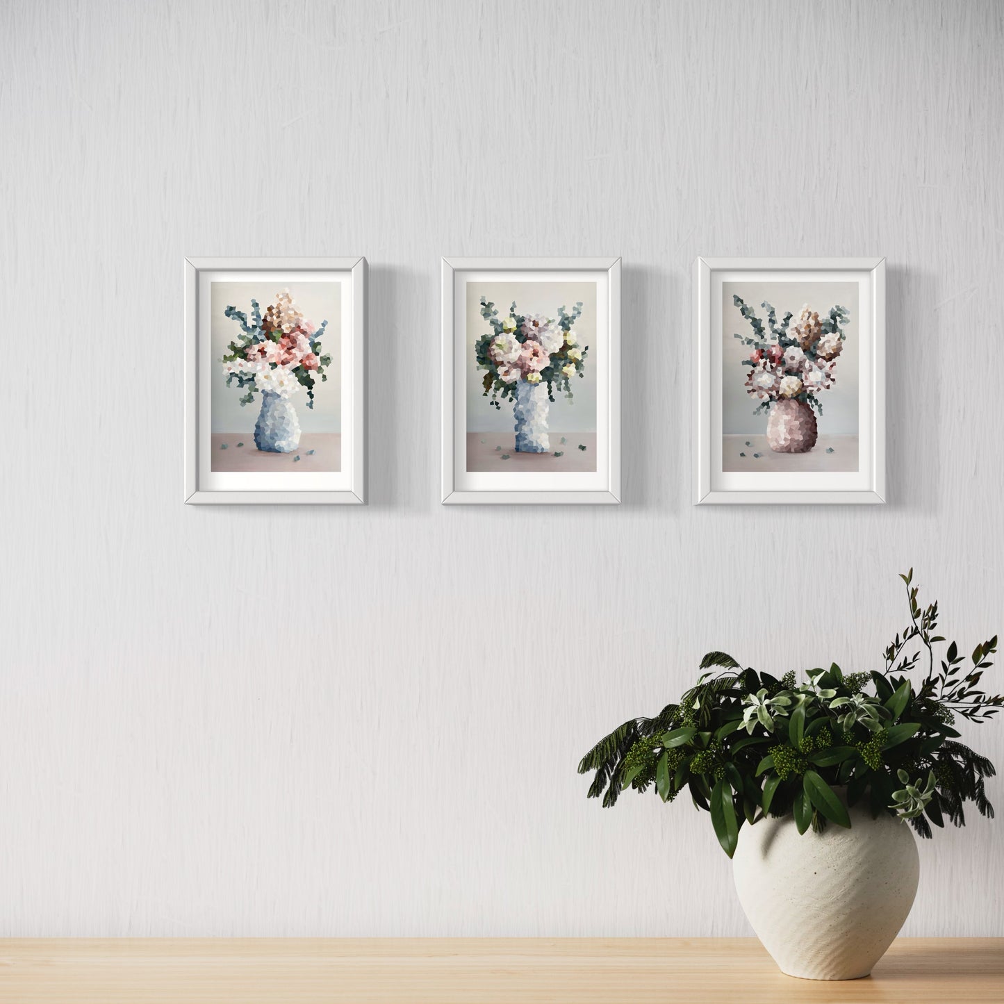 Three Jem Ennis "Symphony of Blooms" prints hanging on wall above a pot plant