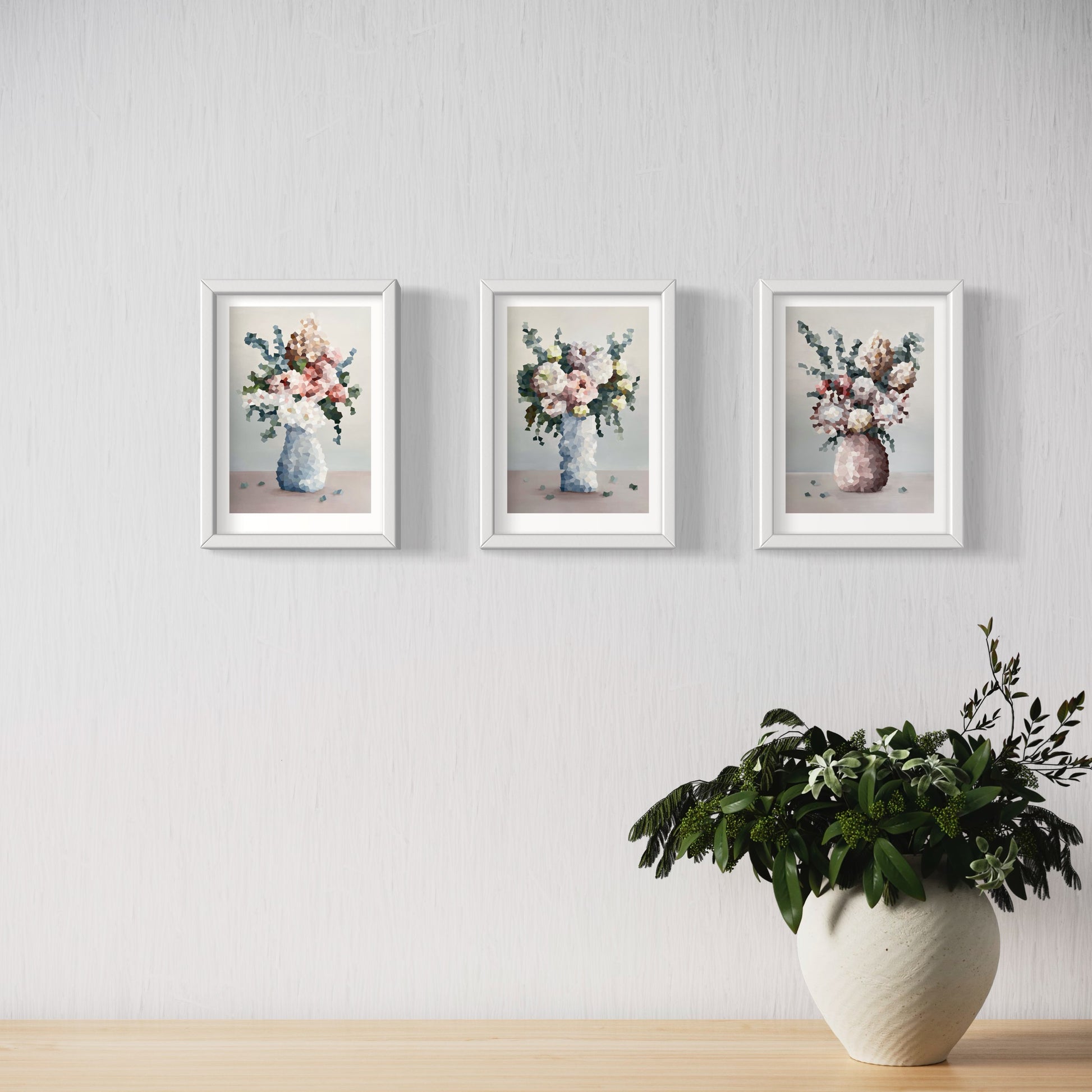 Three Jem Ennis "Symphony of Blooms" prints hanging on wall above a pot plant