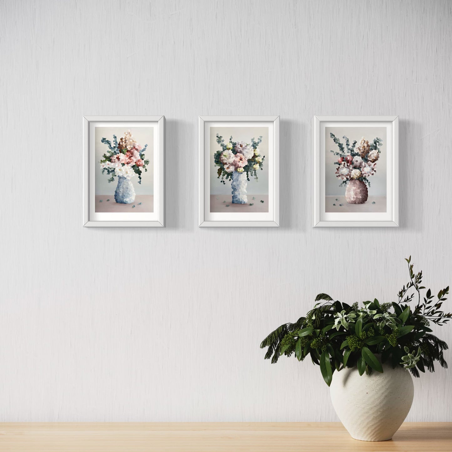 Three Jem Ennis "Symphony of Blooms" prints hanging on wall above a pot plant