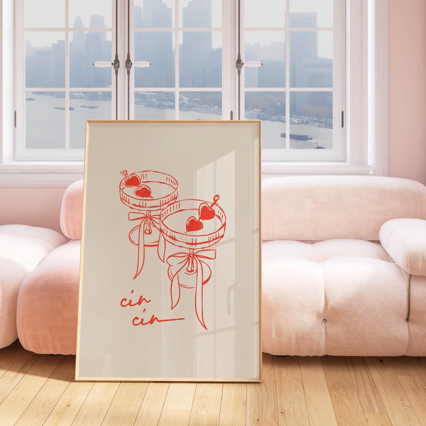 Framed print of two cocktail glasses with cin cin written across the bottom, leaning on a pale pink couch