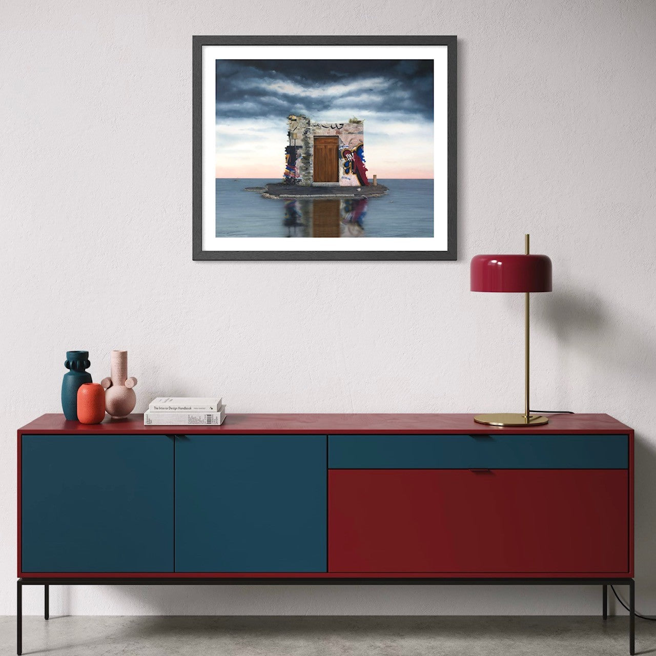 Modern interior with a red and blue sideboard, framed artwork, and decorative items.