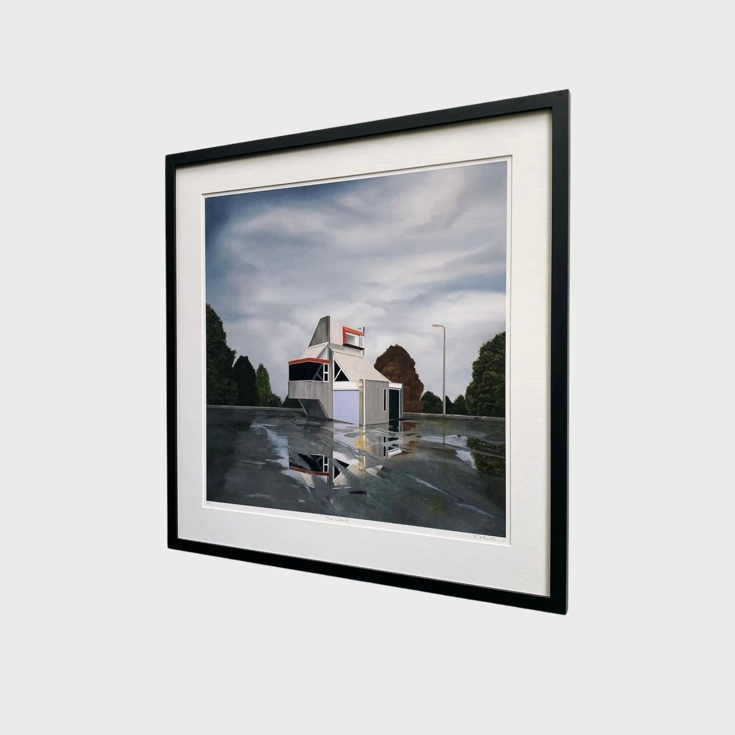 Framed print of with a small abandoned building structure, reflected in a puddle and trees in the background