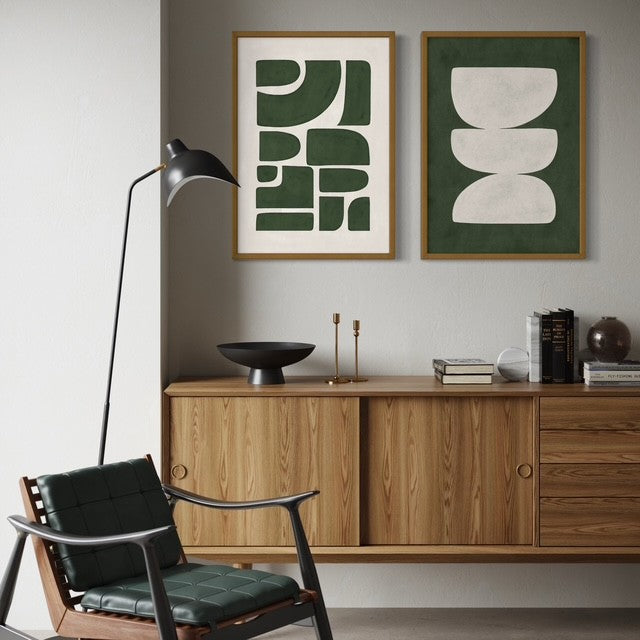 Modern interior with wooden cabinet, black chair, and abstract art print by Solstice Studio on a gray wall.