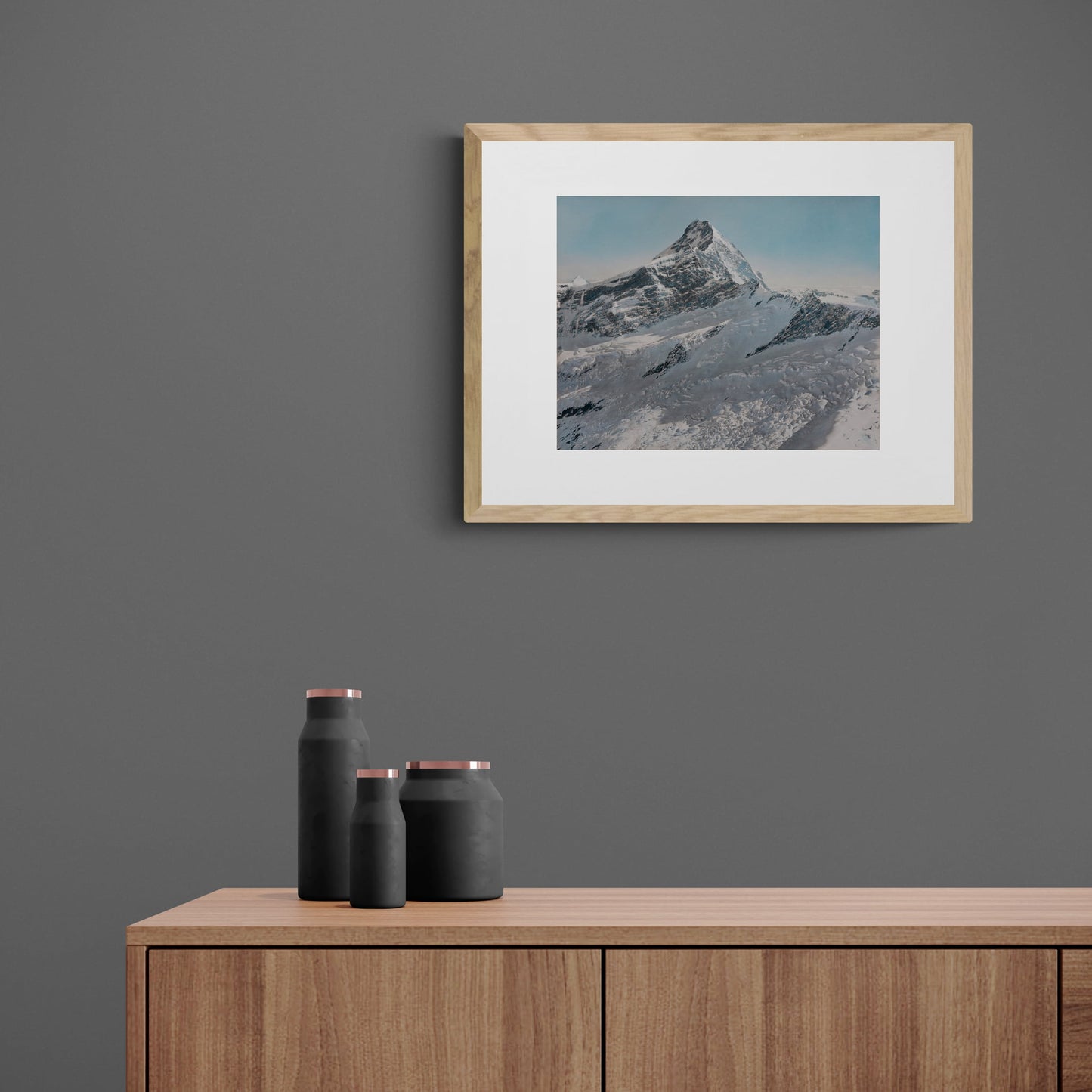 1947 framed photo of snowy mountain peak framed and hanging above console