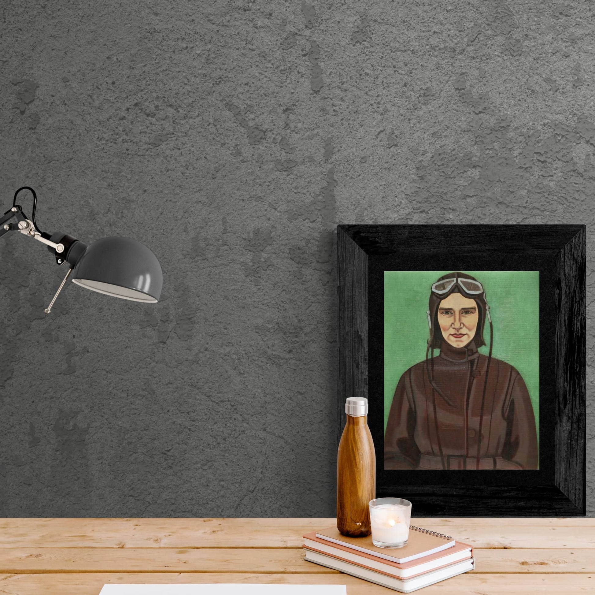 Framed portrait print of an 1930s aviatrix sitting on desk