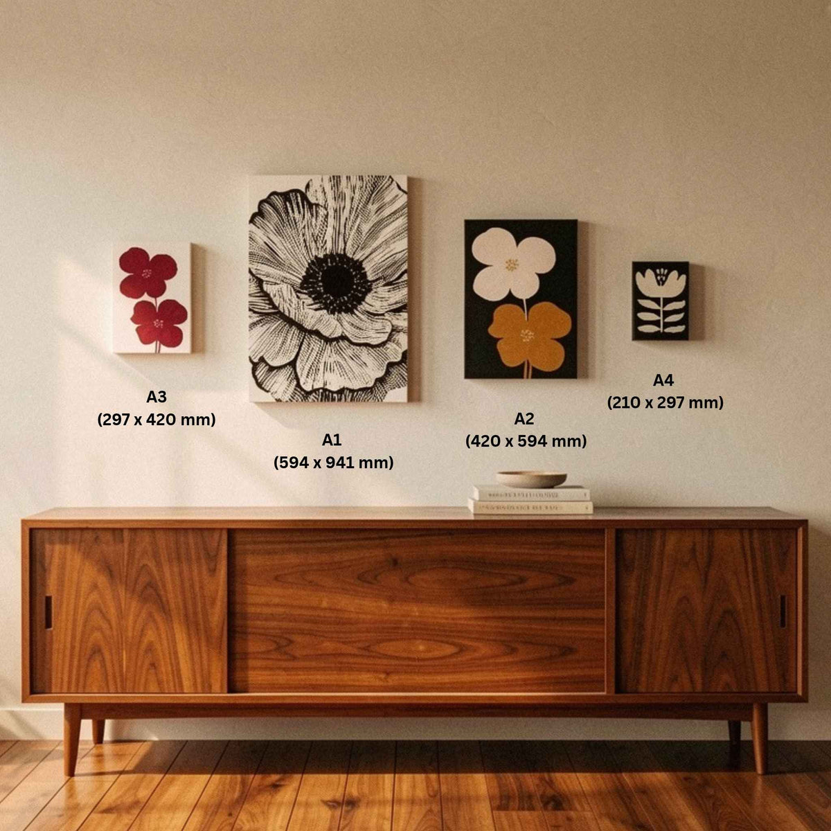 A mid-century modern sideboard console against a beige wall, decorated with four framed floral art prints. The prints are labelled with sizes (A3, A1, A2, A4)  indicating dimensions in millimeters.