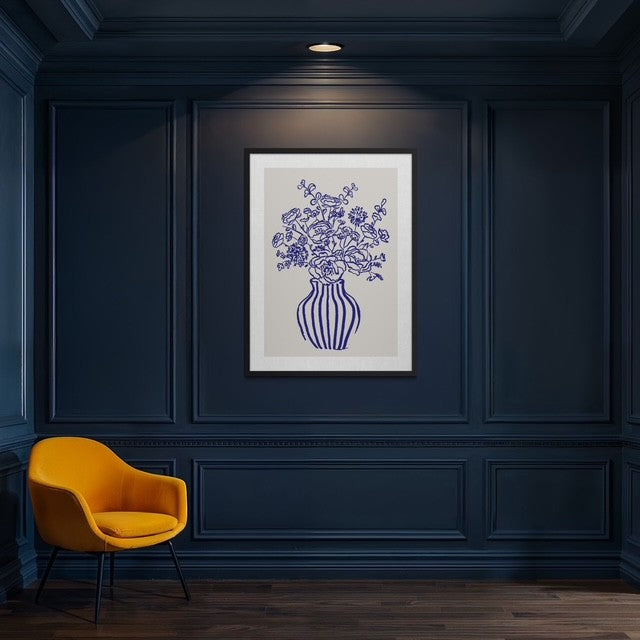 Framed artwork of a floral vase on a dark blue wall with a yellow chair.