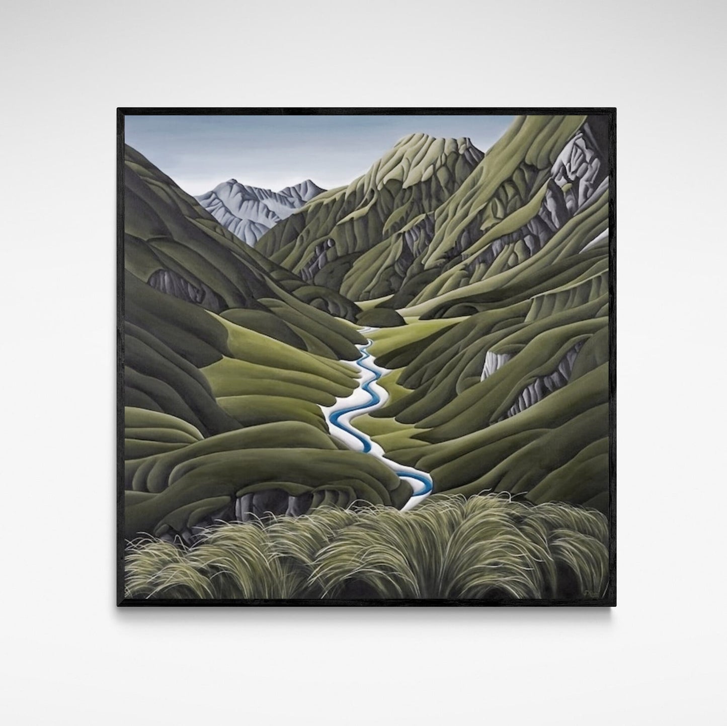Framed print of a green valley with river and mountains.