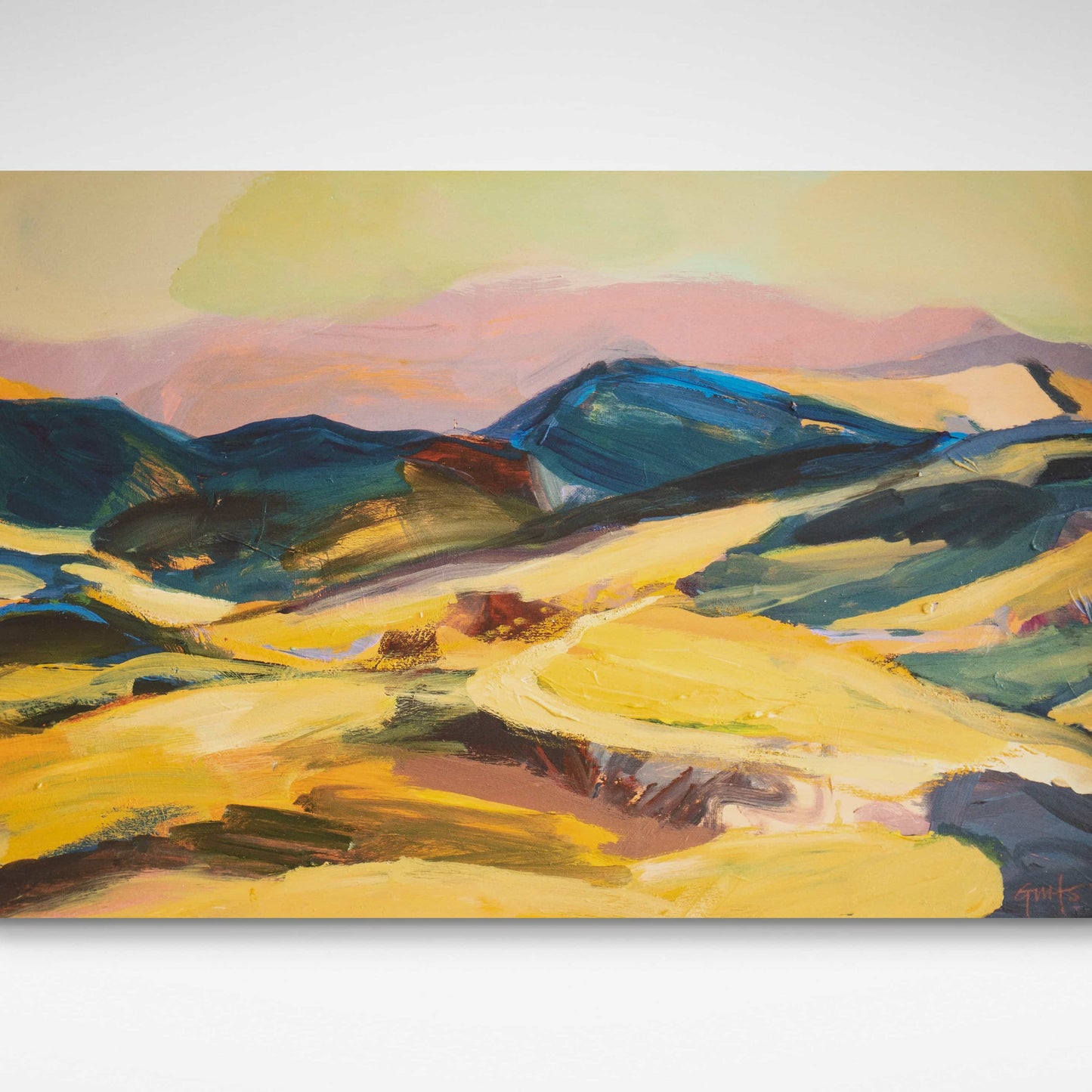 Colourful evening landscape print in yellow and gold with blue hills and pink sky.