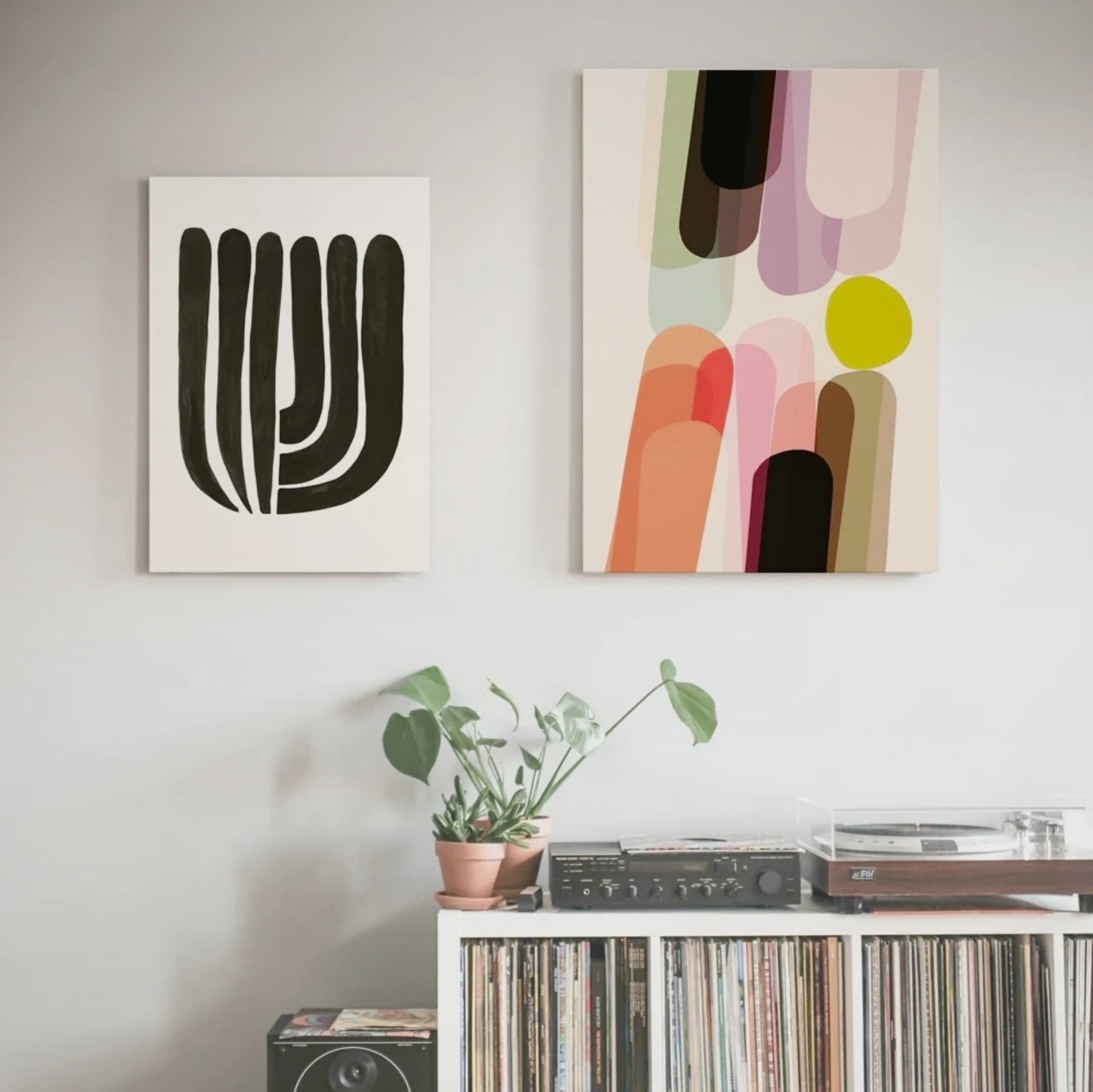 Two Prints Hung Above Shelving holding records and record player.