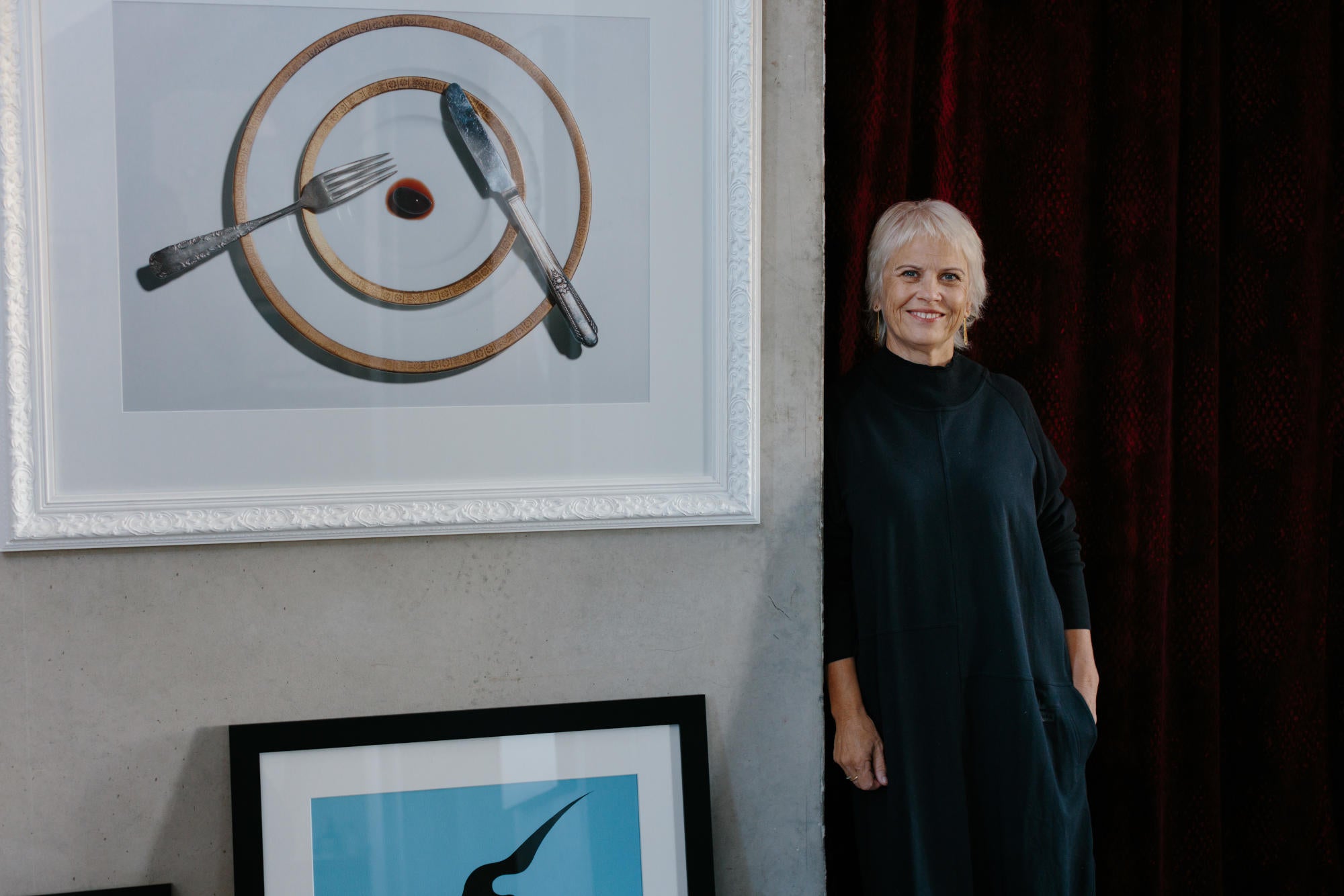Image of Look founder Jan standing beside a wall with art