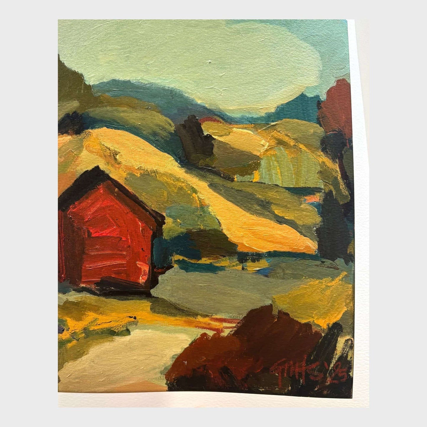 Print of a red hut in a landscape with earthy coloured hills and blue sky.