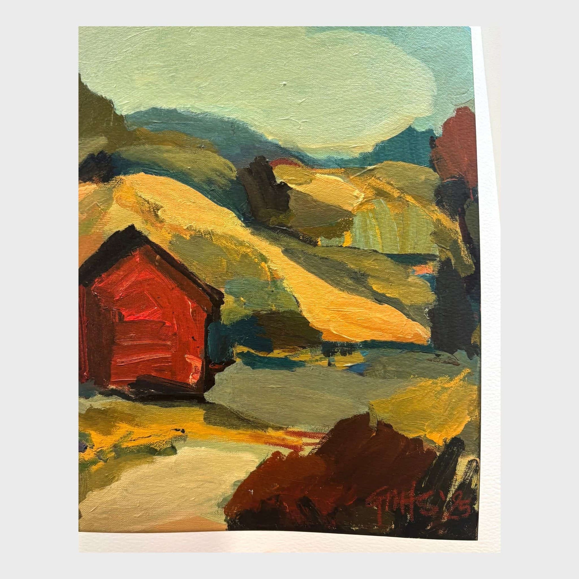 Print of a red hut in a landscape with earthy coloured hills and blue sky.