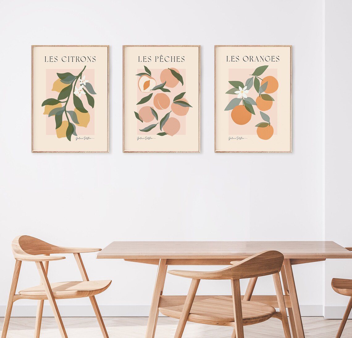 Three framed fruit prints on wall above table and chairs.
