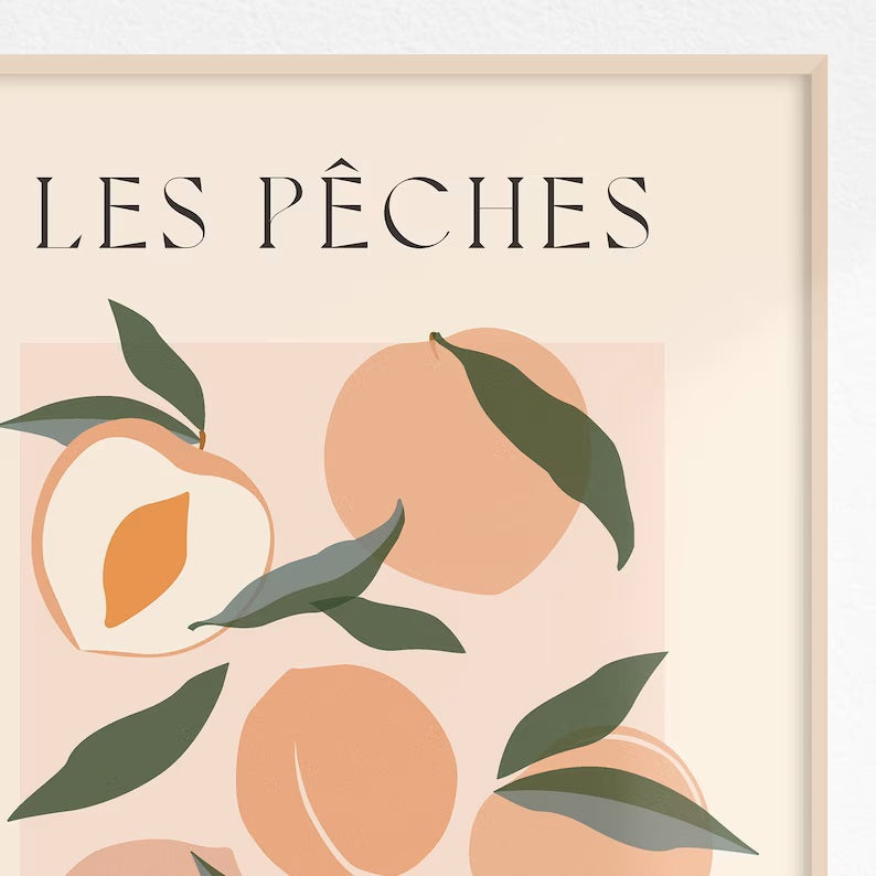Close up of framed print of peaches with green leaves.