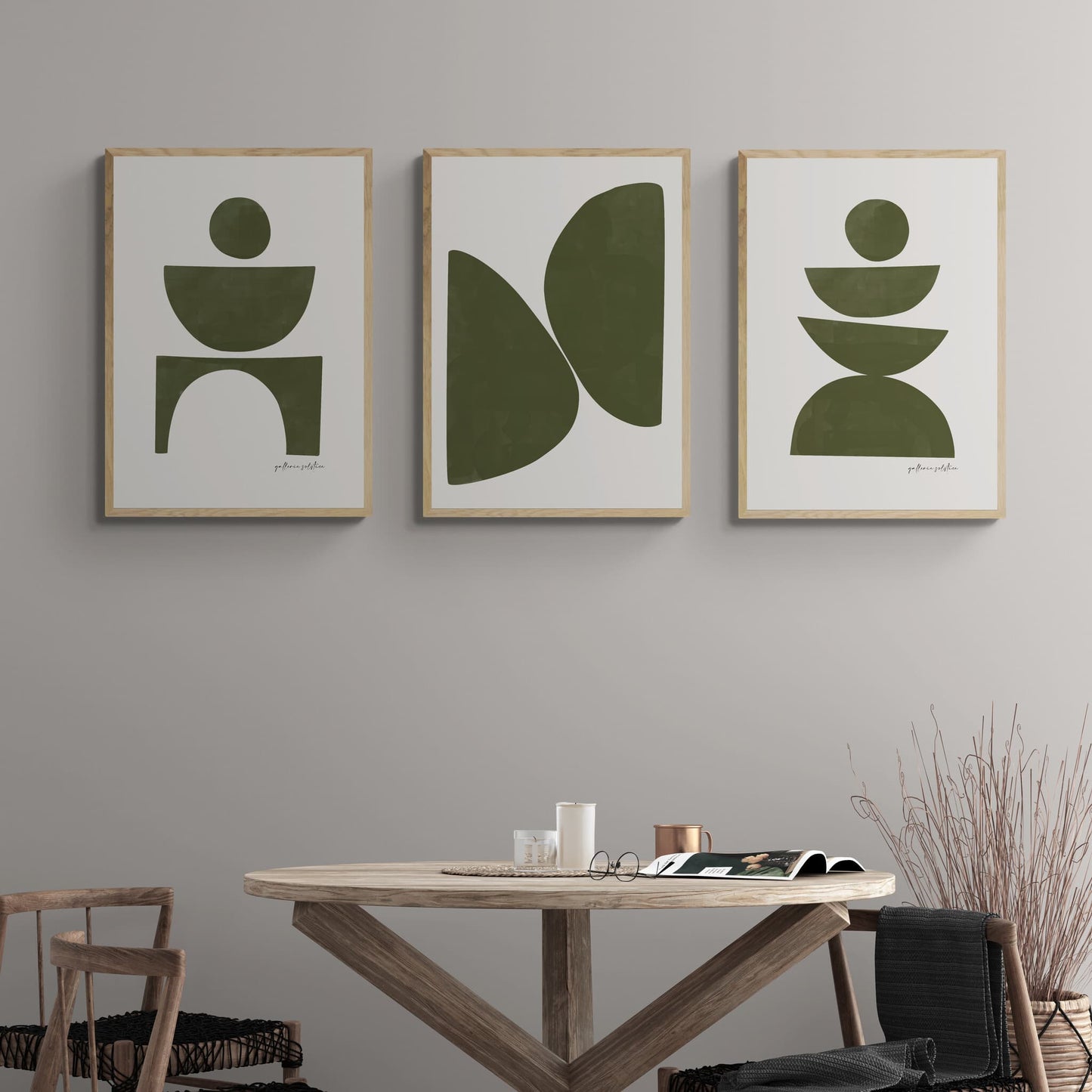 Group of three framed olive green abstract prints hanging above table