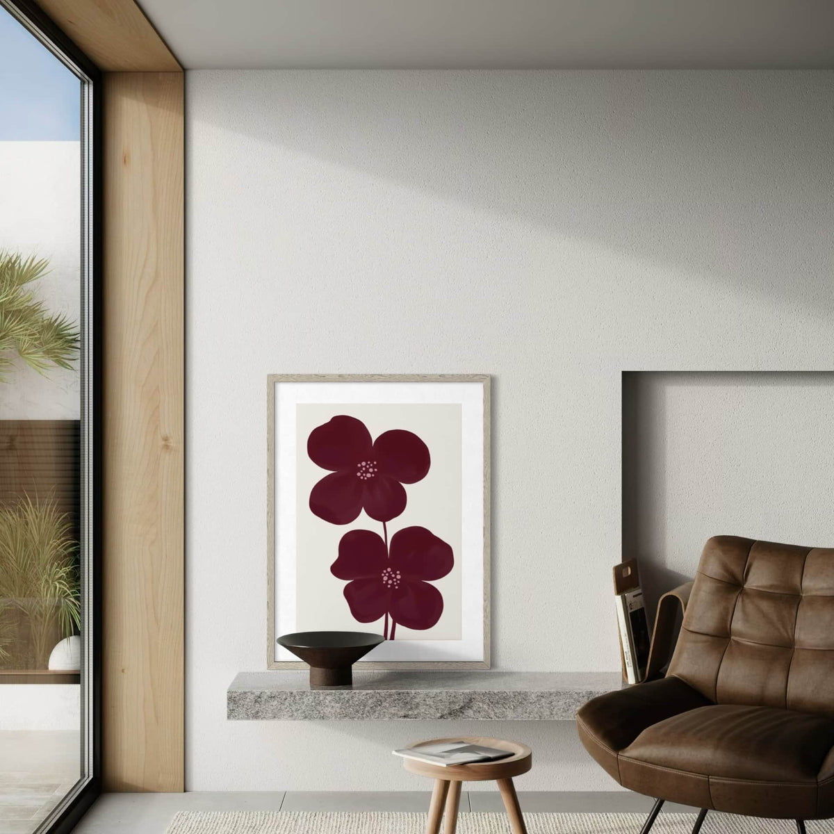 A framed art print from Solstice Studio Prints, featuring two claret red flowers on a light background, styled on a floating shelf in a modern living room. 