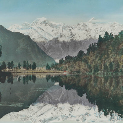 Print of lake with mountains, sky and bush mirrored in it.