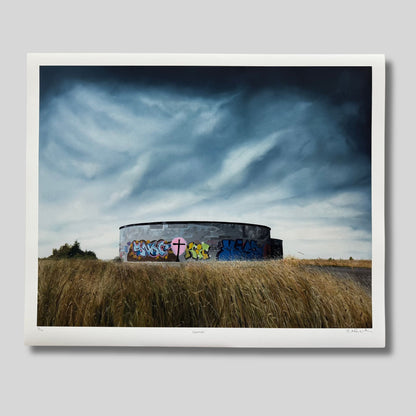 Artwork of a round concrete structure with graffiti on a grassy field under a dramatic sky.