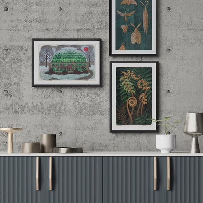 A group of three Eileen Mayo prints hanging on a concrete wall above a grey cabinet