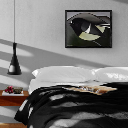 Framed print of a large bird against dark grey and black mountains hanging above an unmade bed.
