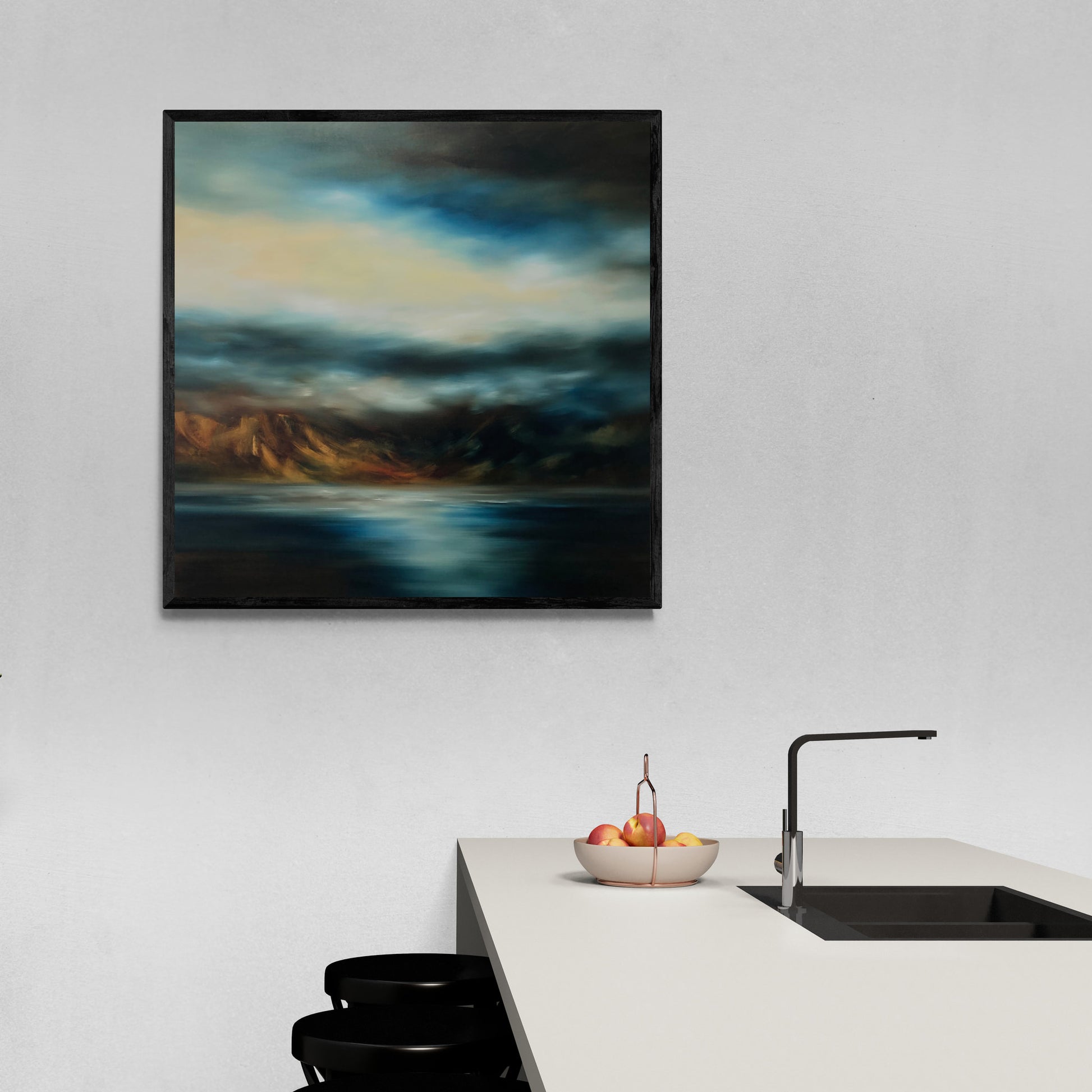 Framed landscape print of sea, mountains and sky hanging on white wall 