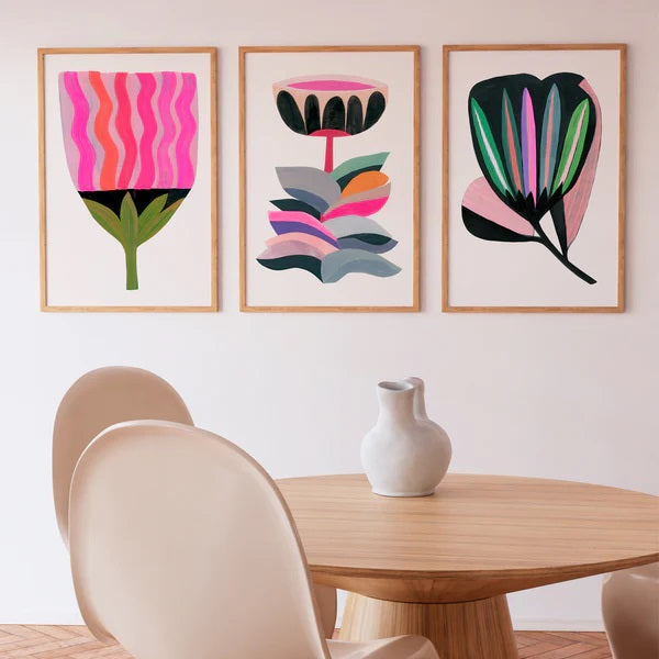 Three framed abstract bright coloured 'My Dream Garden' prints on dining room wall. Each print  depicts a flower.